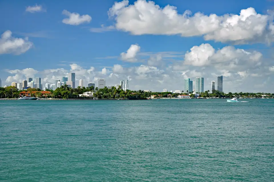 El skyline de Miami se recorta sobre la bahía de Biscayne, con el agua turquesa y un cielo celeste de nubes blancas